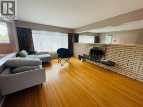 Coquitlam apartment for rent - A living room with a grey couch, a black chair, and a fireplace.