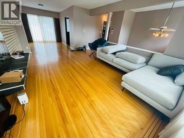 Coquitlam apartment for rent - A living room with a white couch and wooden floors.