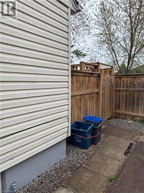 St. Catharines apartment for rent - A small backyard with a wooden fence and two blue bins.
