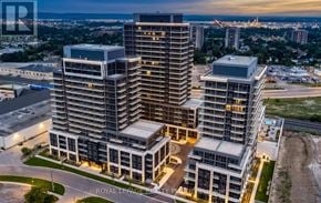 Milton (Tm Timberlea) house for rent - A modern multi-story building complex with a parking lot in front.