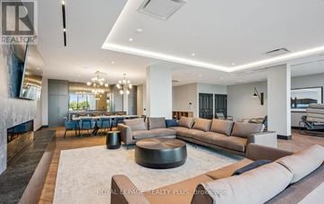 Milton (Tm Timberlea) house for rent - A spacious living room with a large sofa, a coffee table, and a dining table set up.