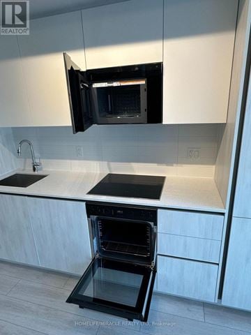 Toronto (Waterfront Communities) condo for rent - A modern kitchen with a black oven and microwave.