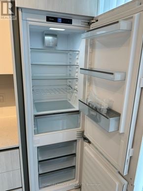 Toronto (Waterfront Communities) condo for rent - A white refrigerator with its door open and shelves visible.