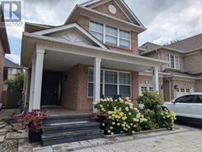 Oakville (Wt West Oak Trails) apartment for rent - A brick house with a white roof and a sign that says "REALTOR" on the top left corner.