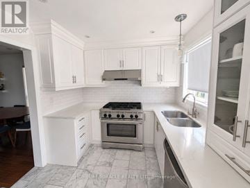Oakville (Wt West Oak Trails) apartment for rent - A white kitchen with a stove top oven and a sink.