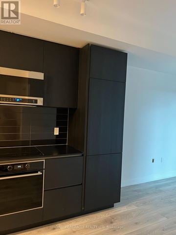 Toronto (Mount Pleasant West) condo for rent - A modern kitchen with black cabinets and stainless steel appliances.