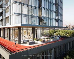 Toronto (Niagara) condo for rent - A modern building with a red running track on the roof.