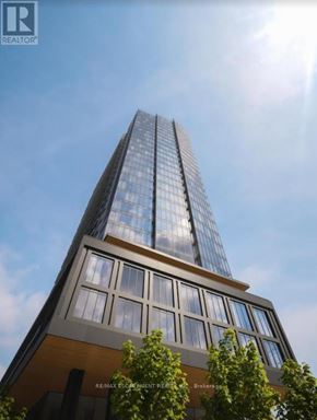 Toronto (Niagara) condo for rent - A tall building with a glass facade and a brown base is shown in the image.