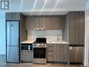 Vaughan (Concord) condo for rent - A modern kitchen with wooden cabinets and stainless steel appliances.