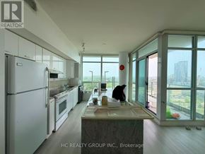 Toronto (Bayview Village) condo for rent - A kitchen with a refrigerator, sink, and large windows.