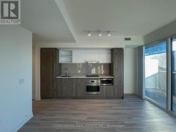 Toronto (Waterfront Communities) condo for rent - A modern kitchen with wooden cabinets and stainless steel appliances.
