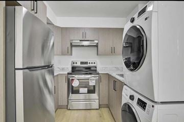 Surrey apartment for rent - A modern kitchen with a stainless steel refrigerator and a white dishwasher.
