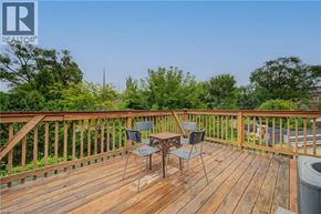 Hamilton apartment for rent - A wooden deck with a table and chairs overlooking a green landscape.