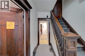 Hamilton apartment for rent - A hallway with a wooden door and a staircase.