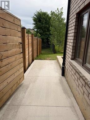 Hamilton (Ancaster) apartment for rent - A wooden fence runs along the side of a concrete walkway.