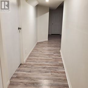 Halton Hills (Georgetown) apartment for rent - A hallway with wood flooring and white walls.