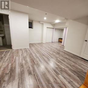 Halton Hills (Georgetown) apartment for rent - A spacious room with wood flooring and white walls.