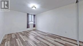 Toronto (Crescent Town) condo for rent - A room with wooden flooring and a window with curtains.