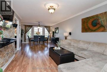 Bradford West Gwillimbury (Bradford) apartment for rent - A living room with a couch, a coffee table, and a painting on the wall.