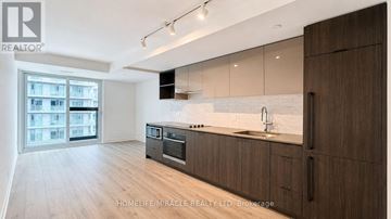 Toronto (Church-Yonge Corridor) condo for rent - A modern kitchen with wooden cabinets and a large window.