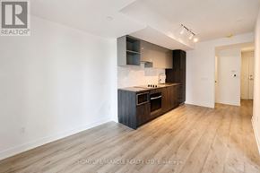Toronto (Church-Yonge Corridor) condo for rent - A modern kitchen with wooden floors and a white wall.