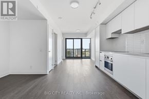 Toronto (Thorncliffe Park) condo for rent - A spacious kitchen with white cabinets and a large window.