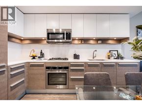 Burnaby apartment for rent - A modern kitchen with a stove top oven and microwave above it.