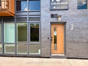 Toronto (Parkwoods-Donalda) townhouse for rent - A building with a wooden door and a sign that says Curlew Drive.