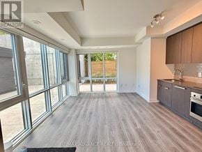 Toronto (Parkwoods-Donalda) townhouse for rent - A spacious room with wooden flooring and large windows.