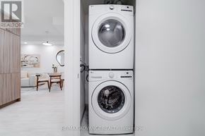 Toronto (Parkwoods-Donalda) townhouse for rent - A white washing machine is in a room with a wooden cabinet and a table.