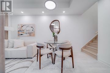Toronto (Parkwoods-Donalda) townhouse for rent - A white living room with a couch, chair, and a painting on the wall.