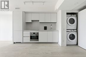 Toronto (Thorncliffe Park) condo for rent - A white kitchen with a washing machine and dryer in the doorway.