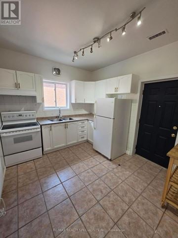 Hamilton (Landsdale) apartment for rent - A kitchen with white cabinets and appliances, a black door, and a window.