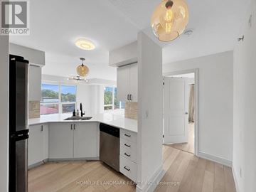 Toronto (Bathurst Manor) condo for rent - A modern kitchen with white cabinets and a large island.