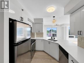 Toronto (Bathurst Manor) condo for rent - A modern kitchen with white cabinets and a black fridge.