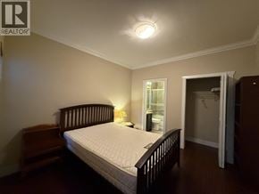 Burnaby apartment for rent - A bedroom with a bed, nightstand, and a window.