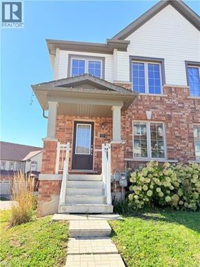 Cambridge townhouse for rent - A house with a front porch and a small front yard.