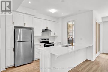 Caledon townhouse for rent - A modern kitchen with white cabinets and stainless steel appliances.