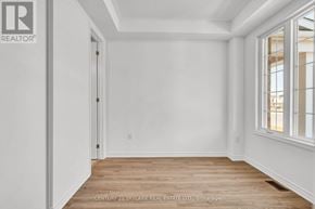Caledon townhouse for rent - A room with wooden floors and white walls, with a window on the right side.