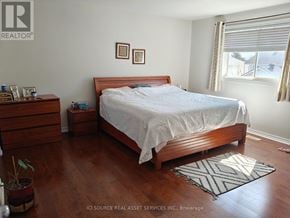 Ottawa apartment for rent - A bedroom with a bed, nightstand, and a plant.