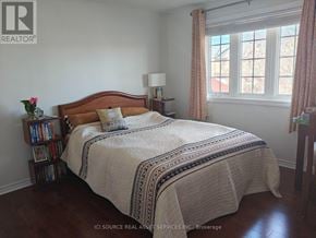 Ottawa apartment for rent - A bedroom with a bed, nightstand, and window.