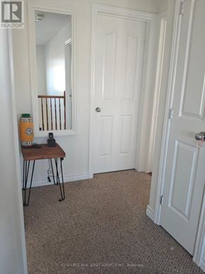Ottawa apartment for rent - A hallway with a white door and a brown table with a yellow container on it.