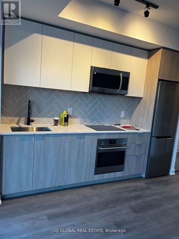Toronto (Islington-City Centre West) house for rent - A modern kitchen with a sink, microwave, and refrigerator.