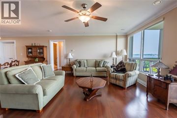 Sarnia condo for rent - A living room with a green couch and a wooden coffee table.