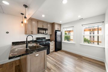 Oakland apartment for rent - A modern kitchen with wooden cabinets and black countertops.