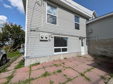 Belleville apartment for rent - A house with a grey siding and a white door is shown.