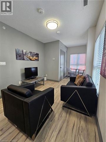 Waterloo condo for rent - A living room with a black couch and a television.
