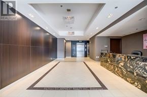 Burlington (Uptown) condo for rent - A hallway with a marble counter and a sign that says RE/MAX Escarpment Realty Inc.