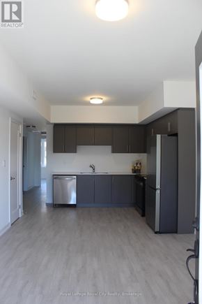 Guelph (Clairfields/Hanlon Business Park) townhouse for rent - A kitchen with dark wood cabinets and a white countertop.