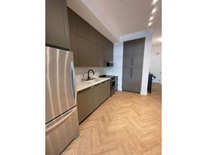 Surrey apartment for rent - A kitchen with a refrigerator, cabinets, and a wooden floor.